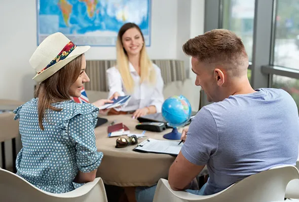 Couple receiving travel tickets from travel agent during personal travel planning consultation.