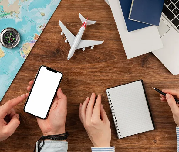 Travel agent discussing travel planning options with clients at a desk with a smartphone.