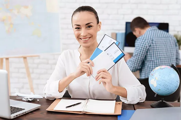 Customer holding travel ticket and smiling after booking with tour agency.